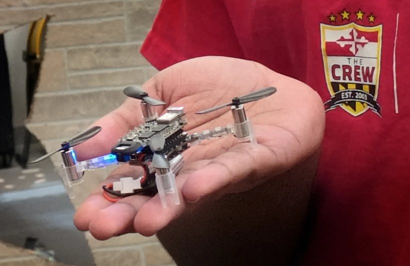 Palm-sized Crazyflie drone held in one hand at the UMD AI Demo Day
